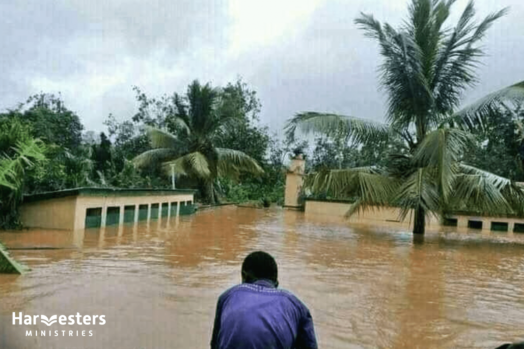 Man in Madagascar overlooking flooding. Harvesters Ministries