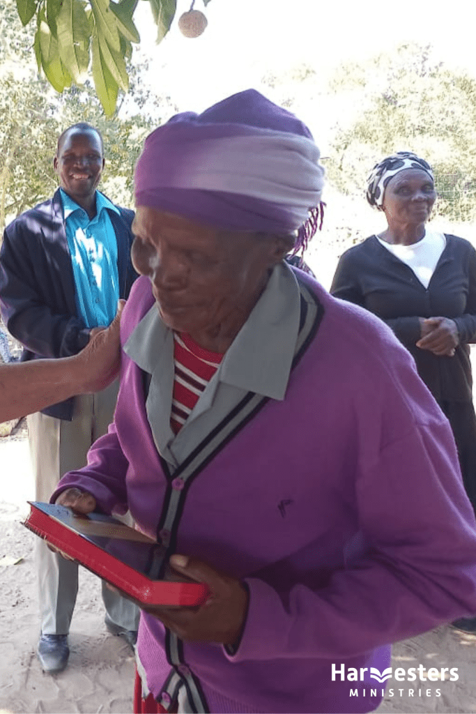 Mamma Francene receives a Bible from Harvesters Ministries