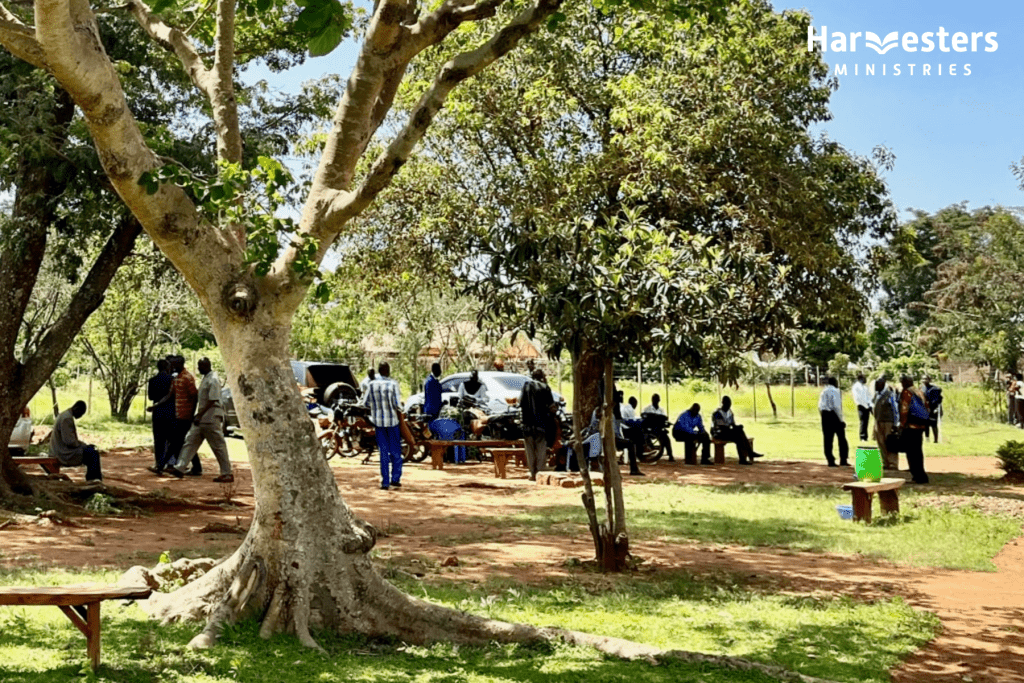 Community gathered under tree in Kenya. Benefits of Harvesters training. Harvesters Ministries.