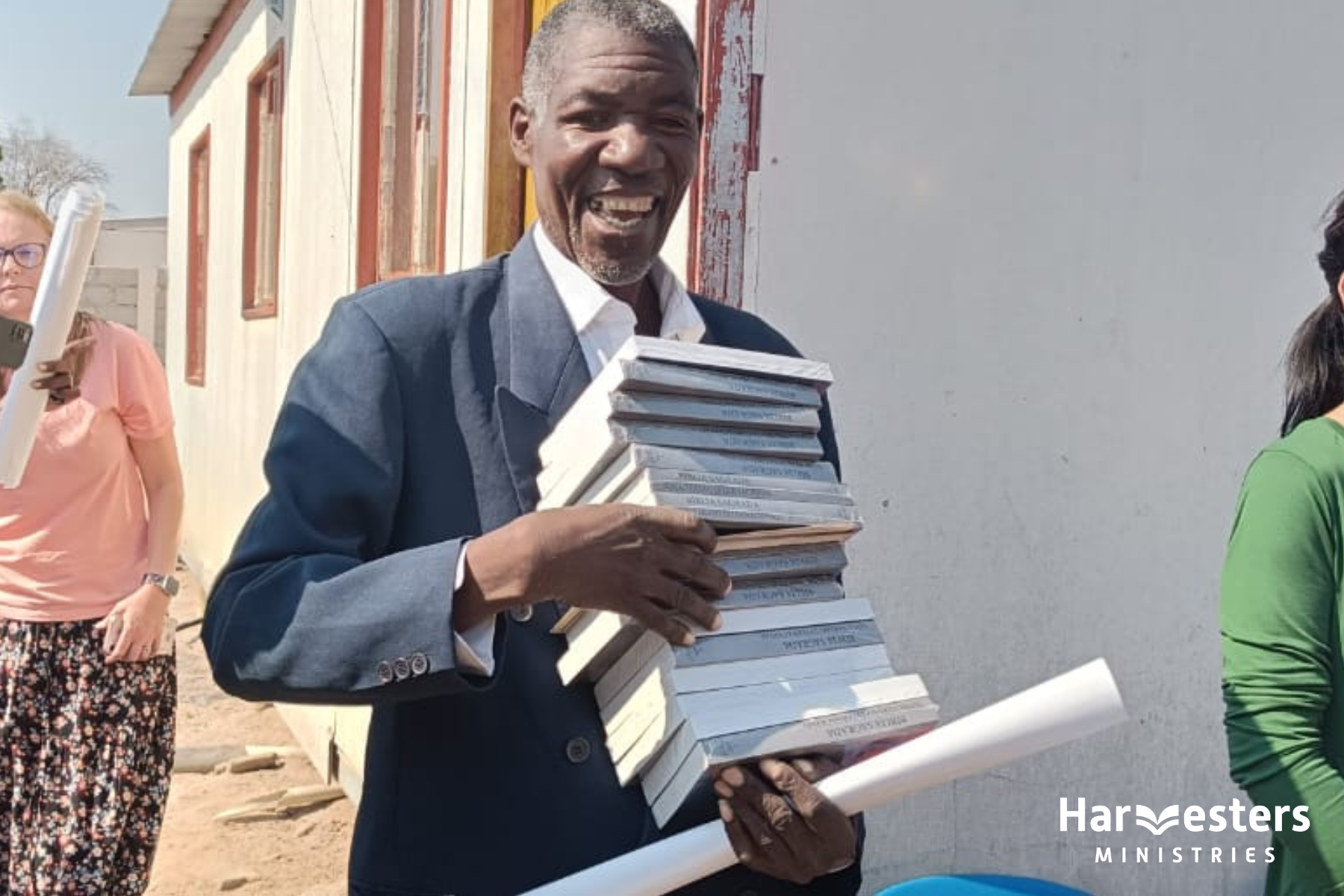 Man smiling with stack of Bibles