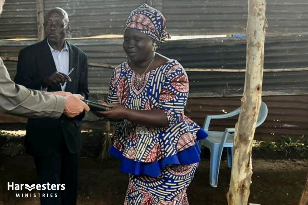 Isah Marida receives Bible. Harvesters Ministries