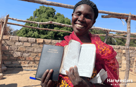 Lady with worn Bible and new Bible. Harvesters Ministries Lady with worn Bible and new Bible. Harvesters Ministries